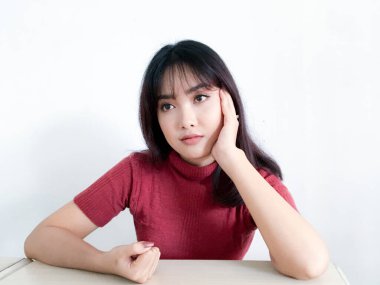 Asyalı güzel kız dışarı bakar ya da çenesini tutarak hayal kurar.