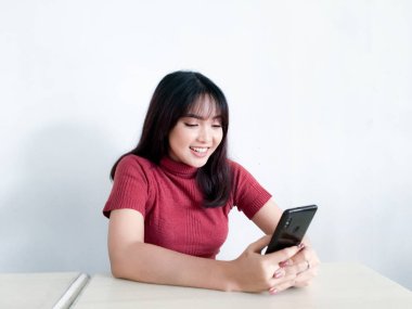 Mutlu hissediyorum ve akıllı telefondan bakan Asyalı güzel bir kadının gülümseyen yüzünü görüyorum. Endonezyalı kadınlar