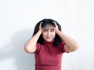 Arka planda el ele tutuşan stresli genç bir kadının portresi. Mutsuz Asyalı kız endişeli surat ifadesiyle aşağıya bakıyor..