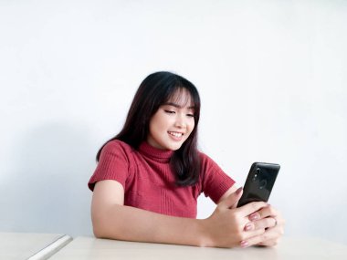 Mutlu hissediyorum ve akıllı telefondan bakan Asyalı güzel bir kadının gülümseyen yüzünü görüyorum. Endonezyalı kadınlar