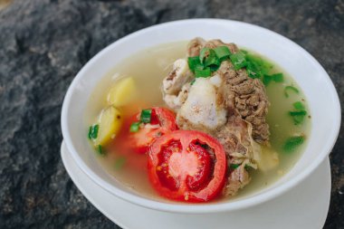 Lezzetli kemik ve et çorbaları, domates, patates ve kasede dilimlenmiş pırasa..