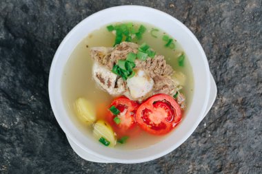 Lezzetli kemik ve et çorbaları, domates, patates ve kasede dilimlenmiş pırasa..