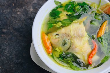 Gurame balık kafası çorbası ya da fesleğen yaprağı, domates, sarı köri ve biberli sup kepala ikan gurubu. Endonezya yemekleri