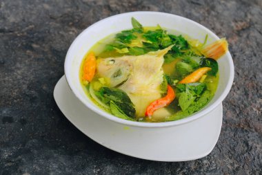 Gurame balık kafası çorbası ya da fesleğen yaprağı, domates, sarı köri ve biberli sup kepala ikan gurubu. Endonezya yemekleri