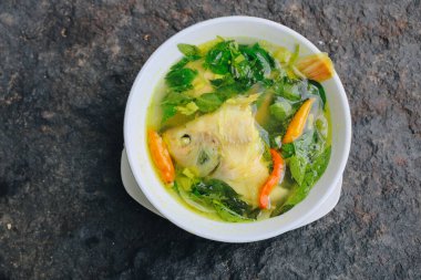 Gurame balık kafası çorbası ya da fesleğen yaprağı, domates, sarı köri ve biberli sup kepala ikan gurubu. Endonezya yemekleri