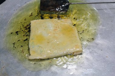 Martabak Telor veya omlet martabak. Yumurta, et ve baharatla doldurulmuş tuzlu tavada kızartılmış hamur işi. Endonezya 'dan geleneksel yiyecek atıştırmalıkları.
