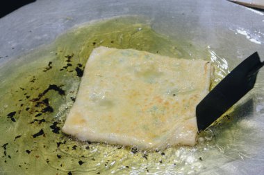 Martabak Telor veya omlet martabak. Yumurta, et ve baharatla doldurulmuş tuzlu tavada kızartılmış hamur işi. Endonezya 'dan geleneksel yiyecek atıştırmalıkları.