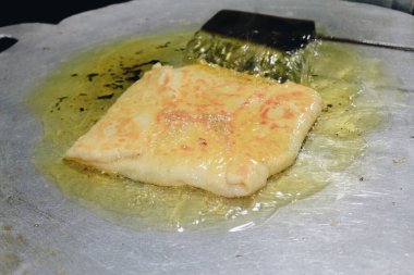 Martabak Telor veya omlet martabak. Yumurta, et ve baharatla doldurulmuş tuzlu tavada kızartılmış hamur işi. Endonezya 'dan geleneksel yiyecek atıştırmalıkları.