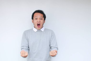 Eli açık Asyalı genç bir adamın şok olmuş yüzü. Reklam modeli konsepti.