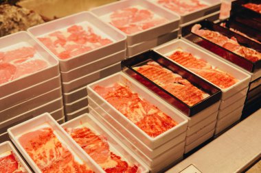 Shabu için tepsilerde çiğ sığır eti ve tavuk eti yığını. Ya da restoranda sıcak tencere..