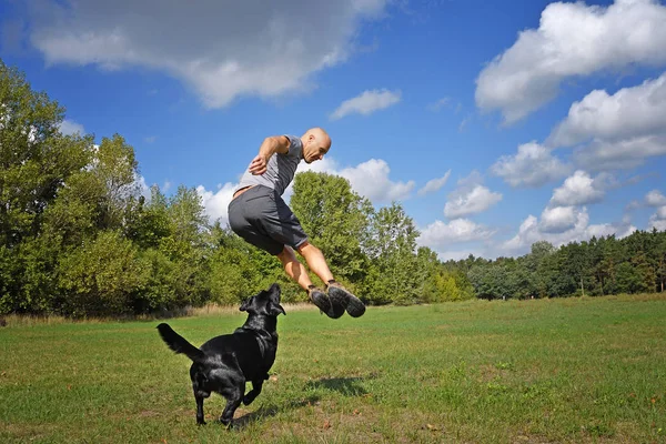 Hombre Saltando Con Perro Parque Día Soleado — Foto de Stock