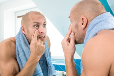 Adam tuvalete aynaya bakar.