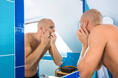 Adam tuvalete aynaya bakar.