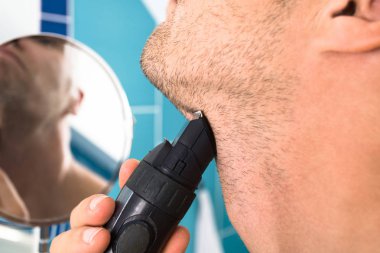 Adam tuvalette sakalını tıraş.