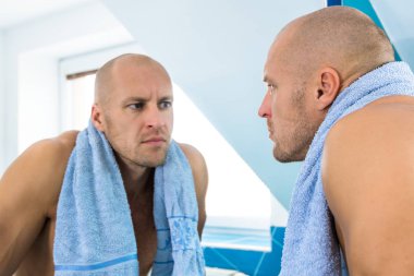 Adam tuvalete aynaya bakar.