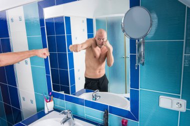 Adam tuvalete aynaya bakar.