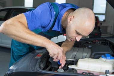 Araba motoru motoru onarın genç araba servis teknisyeni.
