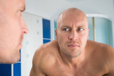 Adam tuvalete aynaya bakar.