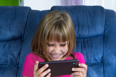 Cep telefonu oyun küçük oturan kız ve oyun.