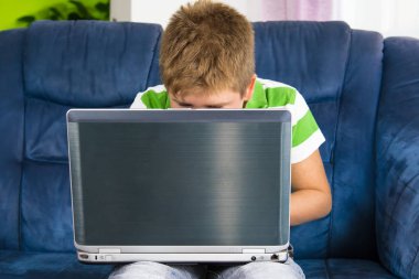 Bilgisayar başında oturan obez küçük çocuk.