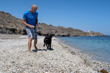 adam köpeğiyle sahilde.