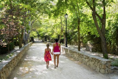 Anne ile kızı parkta yürüyüş.