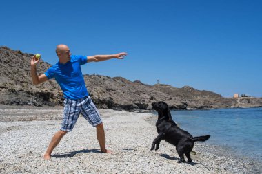 adam köpeğiyle sahilde.