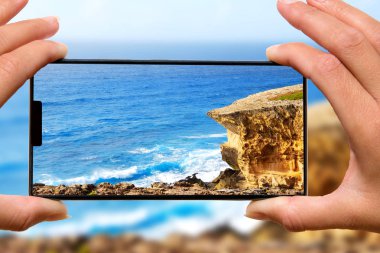 Hareket eden telefon fotoğraf rock beach kadınla.