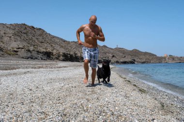 adam köpeğiyle sahilde.