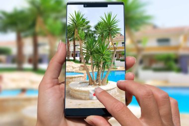 Hareket eden telefon fotoğraf egzotik resort havuzlu kadınla.