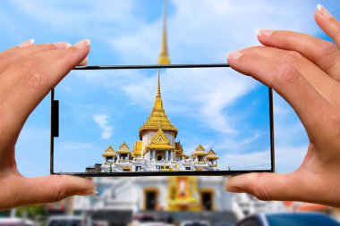 Kadın cep telefonu ile Tapınak Tayland Turları Fotoğraf Sayısı.