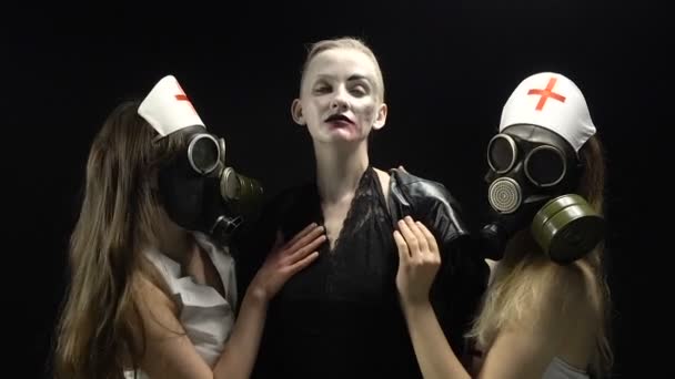 Дві дівчини в газовій масці з жінкою в чорному — стокове відео