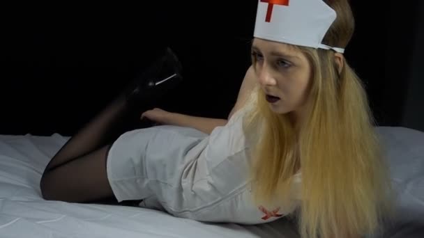 Infirmière blonde sexuelle couchée au lit — Video