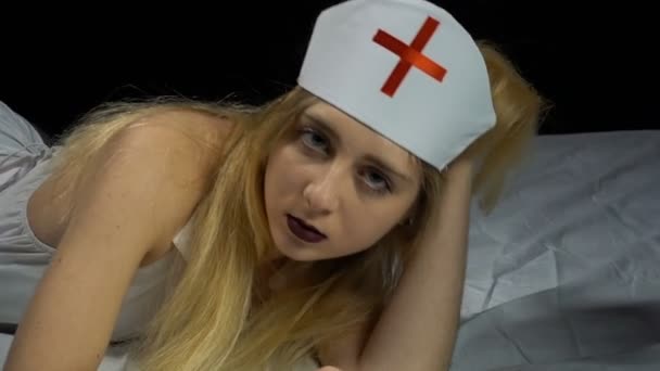 Ερωτικά ξανθιά νοσοκόμα κορίτσι ξαπλωμένο στο κρεβάτι — Αρχείο Βίντεο