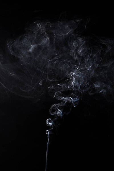 White smoky cloud of aroma stick on black background