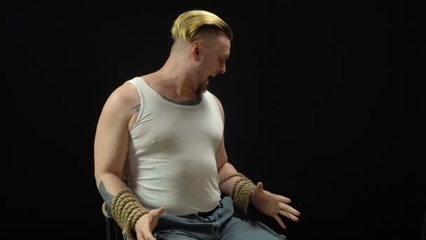 Jonge blonde man vastgebonden op de stoel — Stockvideo
