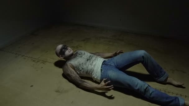 Лежащий сумасшедший лысый мужчина в комнате — стоковое видео