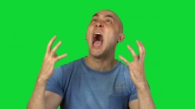 Yeşil zemin üzerine genç kel adam bağırıyor