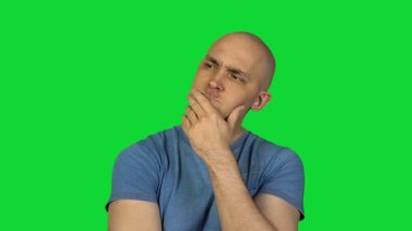 Yeşil zemin üzerine düşünceli kel adam