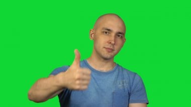 Yeşil arka plan üzerinde gösteren başparmak kel adam