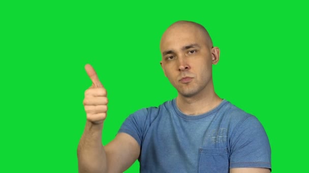 Показывая, как и не нравится лысый человек на зеленом фоне — стоковое видео