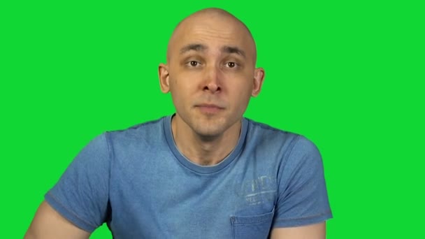 Удивленный молодой лысый мужчина на зеленом фоне — стоковое видео