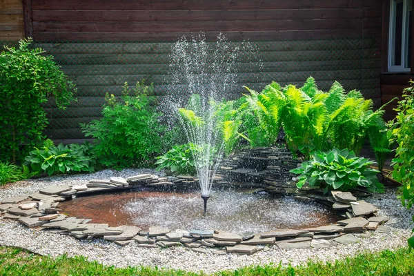 Fountain and green grass in summer time — Stock Photo, Image