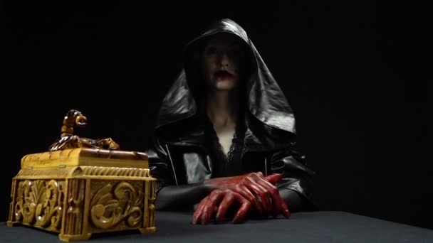Girl in black hood opening horror box — Stock Video