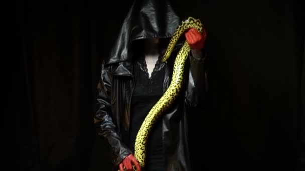 Frau im schwarzen Mantel mit Python — Stockvideo