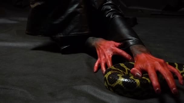 Images de femme aux mains sanglantes et serpent sur fond noir 