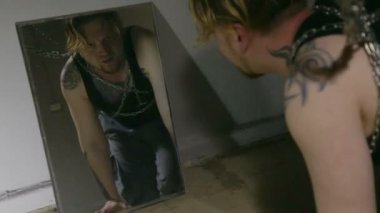 Aynaya bakarak zincire bağlı adamın