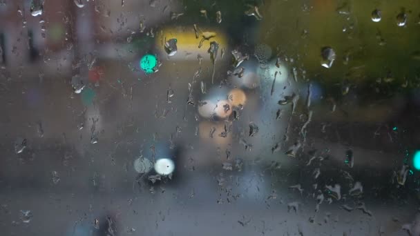 Gotas rodantes de la lluvia en la strret, vista desde la ventana — Vídeo de stock