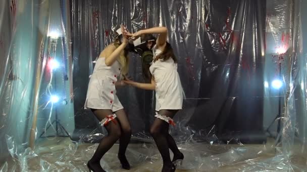 Två unga dansar sjuksköterskor i gasmask — Stockvideo