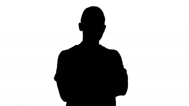 Silhouette of young man with arms crossed — Stock Video